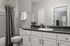 Sleek bathroom design with elegant fixtures, modern gray accents, spacious countertop, and abundant natural light.