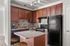 Charming kitchen with rich wooden cabinets, modern appliances, and a cozy island with seating.