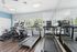 Modern gym with sleek treadmills, exercise bikes, and floor-to-ceiling mirrors, offering a bright and motivating workout space with natural light.