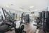 Bright and modern gym with state-of-the-art exercise equipment and elegant wood flooring, perfect for a dynamic workout experience.