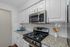 Modern kitchen with sleek granite countertops, stainless steel appliances, and elegant white cabinetry.