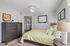 Bright and inviting bedroom with modern decor, featuring a cozy bed with patterned bedding, elegant dresser, and thoughtful accents.