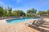 Inviting outdoor pool area with comfortable lounge chairs and lush greenery, perfect for relaxation and entertainment.