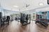 Bright and modern fitness center with state-of-the-art gym equipment and large mirrors, offering an invigorating workout experience.