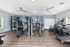 Spacious and modern apartment gym featuring state-of-the-art fitness equipment and sleek hardwood flooring.