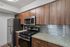 Modern kitchen with stainless steel appliances, sleek granite countertops, and elegant wooden cabinetry.
