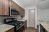 Modern kitchen with sleek stainless steel appliances, granite countertops, and elegant wood cabinetry.