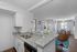 Elegant open-concept living space featuring a modern kitchen with granite countertops, cozy sitting area, and a sunlit dining room with stylish decor.