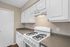 Sleek kitchen with white cabinetry and modern gas stove offering spacious countertops for culinary creativity.