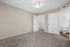 Inviting bedroom with plush carpet, ceiling fan, walk-in closet, and bathroom access, perfect for comfort and convenience.
