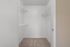 Spacious walk-in closet with built-in wire shelving and plush carpet flooring, perfect for organized living.
