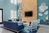 Chic living room with high ceilings, modern decor, and a large TV mounted on a wooden accent wall.