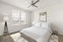 Bright bedroom with modern decor, featuring a comfortable bed, stylish lamp, and elegant artwork.