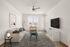 Bright and welcoming living room with modern furniture, large windows, and a stylish ceiling fan.