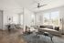 Chic living room with large windows, modern furnishings, and a cozy dining area.