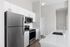 Modern kitchen with sleek stainless steel appliances, white cabinetry, and elegant quartz countertops.