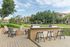 Inviting outdoor space featuring modern BBQ grills, stylish seating, and lush landscaping, perfect for entertaining and relaxation in a serene apartment community.