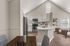 Modern open-concept kitchen and dining area with sleek stainless steel appliances, elegant white cabinetry, and a cozy living space featuring natural light.