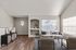 Elegant living room with modern decor, featuring a plush sofa, stylish armchairs, and abundant natural light from large windows.