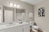 Modern bathroom with sleek white vanity, elegant light fixtures, and contemporary wall art.