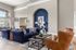 Elegant living room with plush blue sofas and leather chairs, accented by sophisticated decor and ample natural light.
