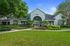 Elegant residential building with a charming archway entrance, lush landscaping, and a vibrant garden path.