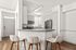 Modern kitchen with sleek white cabinetry, stainless steel appliances, and a breakfast bar with comfortable seating.