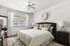 Bright, inviting bedroom with a plush bed, elegant decor, and abundant natural light through a large window.