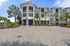 Elegant apartment complex showcasing modern architecture with lush palm trees and a welcoming entrance.