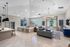Elegant and spacious living area with cozy seating, large windows, modern lighting, and a sleek kitchen bar in a stylish apartment.