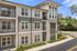 Apartment exterior with brick, tan siding and white siding in the day time