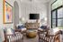 Indoor community living area with cushioned chairs and a television on the wall