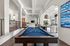Indoor community area featuring a blue pool table with pool balls and pool sticks