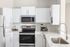 Contemporary kitchen with stainless steel appliances, white cabinetry, and modern fixtures.