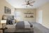 Elegant bedroom interior featuring a plush bed, decorative art, stylish shelves, and a modern ceiling fan.
