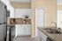 Sleek kitchen with stainless steel appliances, white cabinetry, and elegant countertops.