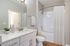 Renovated bathroom with sleek fixtures, elegant vanity, and a pristine bathtub.
