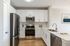 Modern kitchen with sleek stainless steel appliances, white cabinetry, and elegant countertops, perfect for culinary enthusiasts.