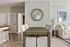 Modern dining area with elegant wooden table, plush chairs, and a stylish wall mirror, adjacent to cozy living room.