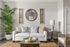 Chic living room with elegant white sofa, cozy pillows, stylish d&eacute;cor, and a lush green plant creating a welcoming ambiance.