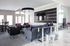 Elegant and modern living room with stylish seating, large flat-screen TV, and sophisticated decor accents in sleek metallic and purple hues.