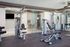Modern apartment gym filled with sleek exercise equipment and mirrored walls, creating an inviting space for fitness enthusiasts.