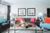 Bright and modern living room with colorful cushions, elegant wall art, and chic decor creating a welcoming space.