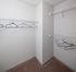Spacious walk-in closet with ample shelving and carpeted flooring, perfect for organized storage.