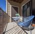 Charming balcony with modern blue chairs and small table, perfect for outdoor relaxation.