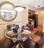Modern dining area with elegant table setting, stylish chandelier, and a glimpse of a well-equipped kitchen.