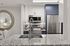 Modern kitchen with sleek stainless steel appliances, elegant granite countertops, and stylish cabinetry, featuring a chic round mirror accent.