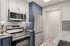 Modern kitchen with sleek stainless steel appliances, elegant granite countertops, and crisp cabinetry in a stylish apartment setting.