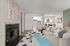 Elegant living room with a cozy fireplace, stylish sofa, and chic modern decor. Open view to a sleek kitchen and dining area, perfect for relaxation and entertaining guests.