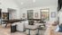 Contemporary living room with elegant gray sofas, stylish decor, and a sleek pool table, featuring large windows offering serene forest views.